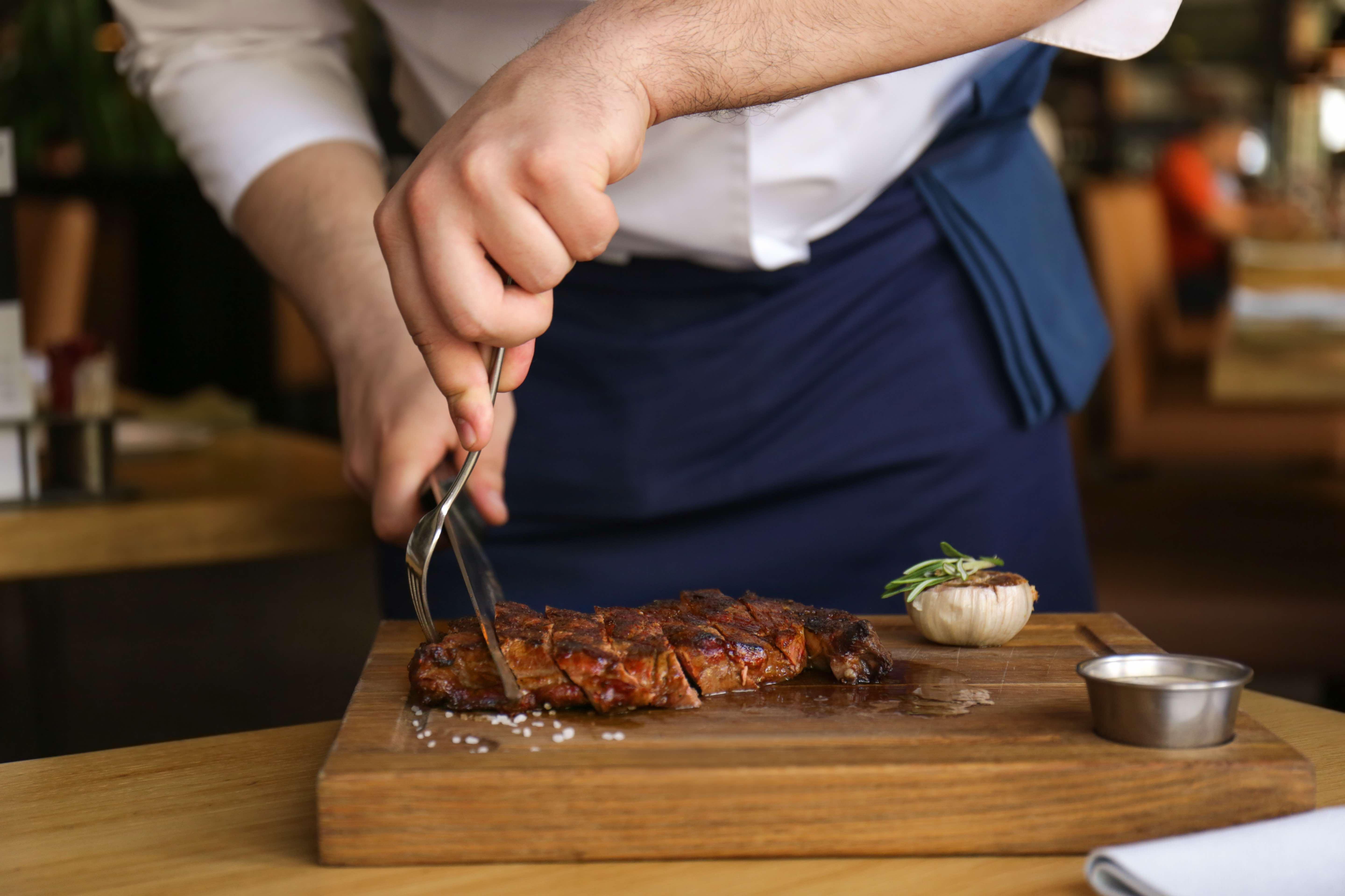 Voco Dubai By Ihg Hotel Luaran gambar A chef cutting a steak