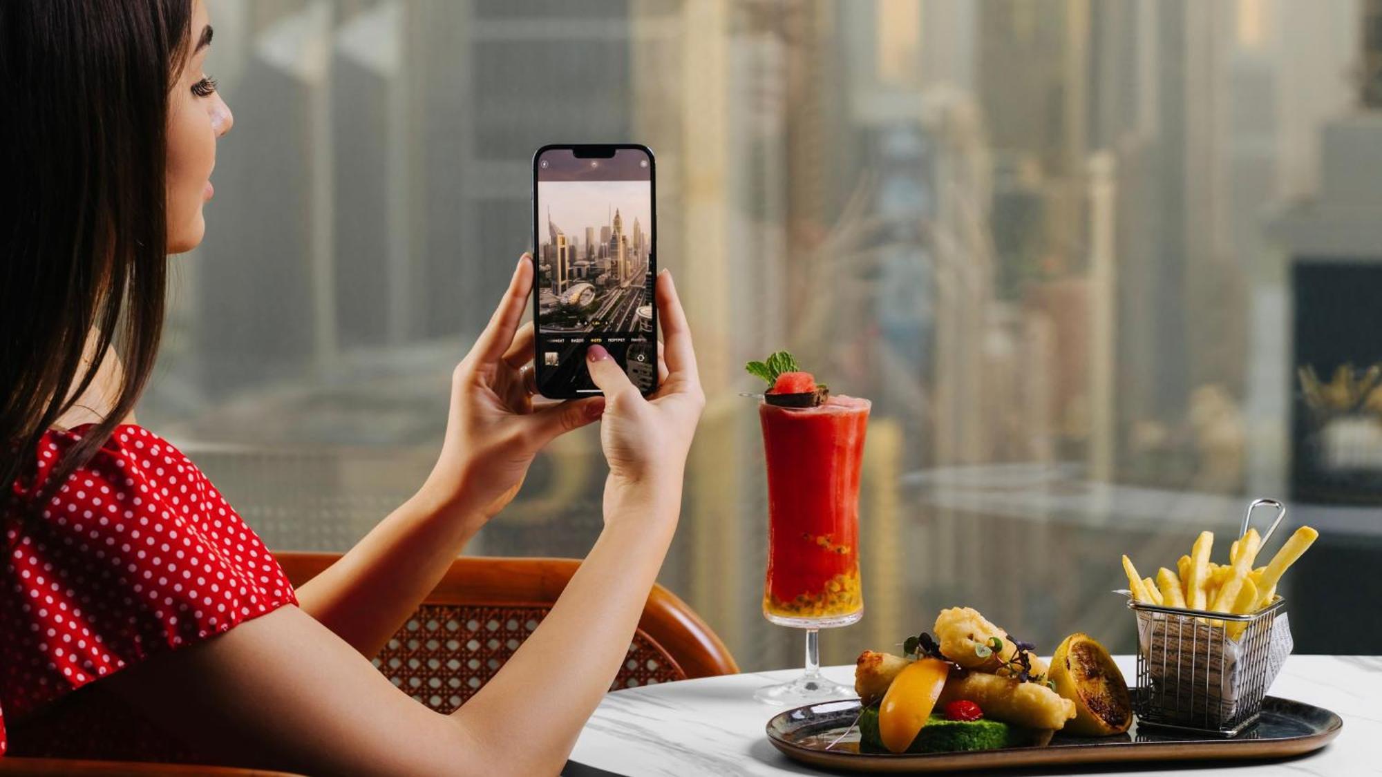 Voco Dubai By Ihg Hotel Luaran gambar A woman taking a photo with a smartphone